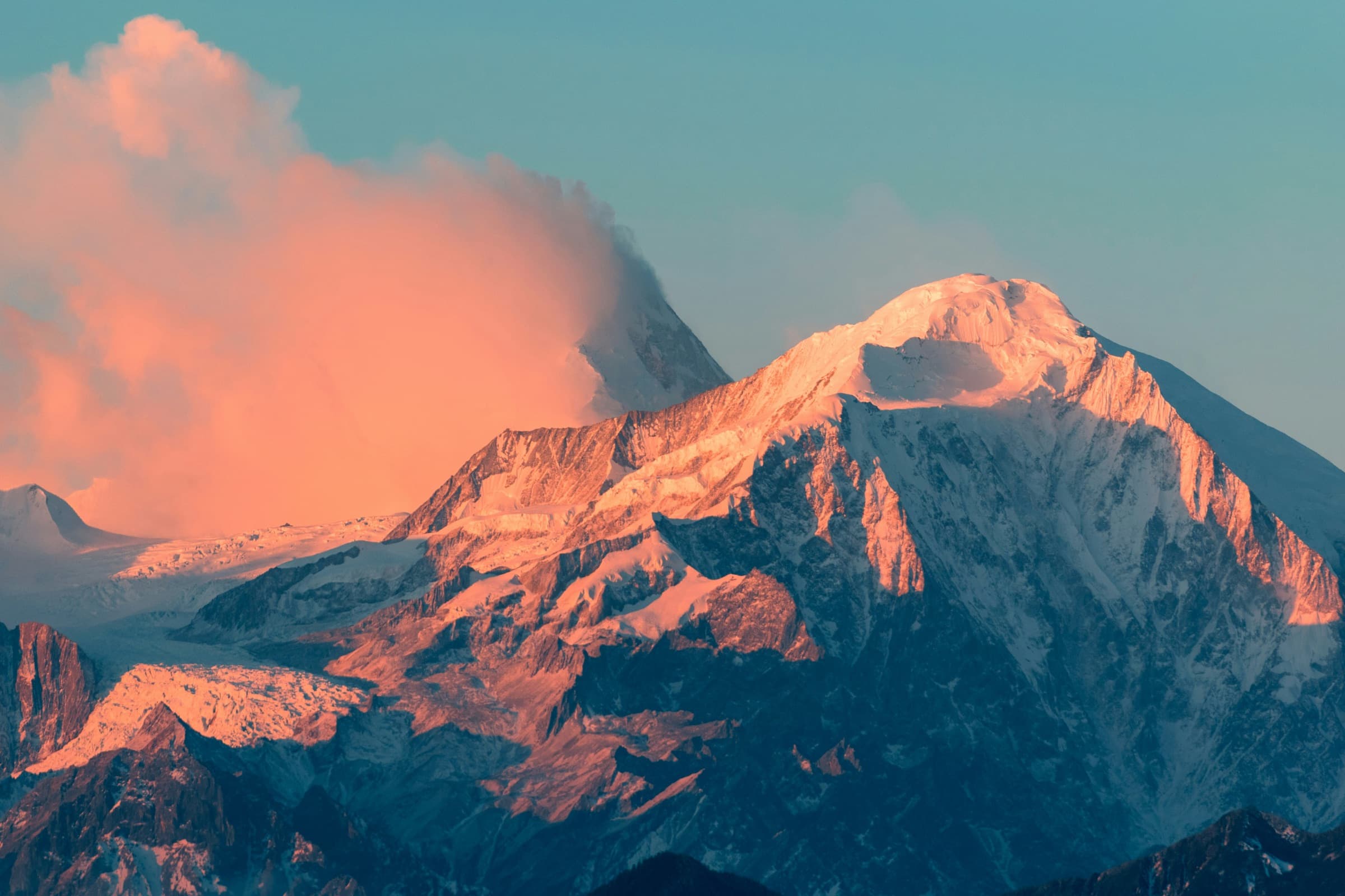 Snow-capped mountain peak lit by sunset light
